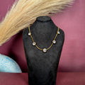 Front view of the Bezel Crystal Necklace displayed on a black bust showcasing the evenly spaced bezel-set crystal stations.