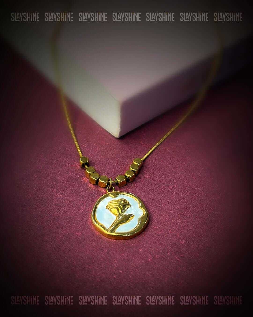 Golden Rose Medallion Necklace with gold-tone chain and round ivory rose pendant in a polished medallion