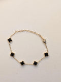 Midnight Clover Bracelet with black clover charms on a delicate gold-tone chain and adjustable clasp