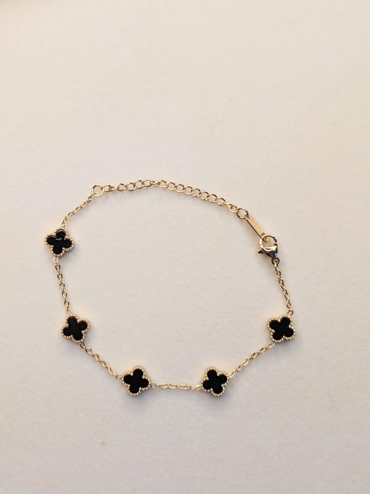 Midnight Clover Bracelet with black clover charms on a delicate gold-tone chain and adjustable clasp