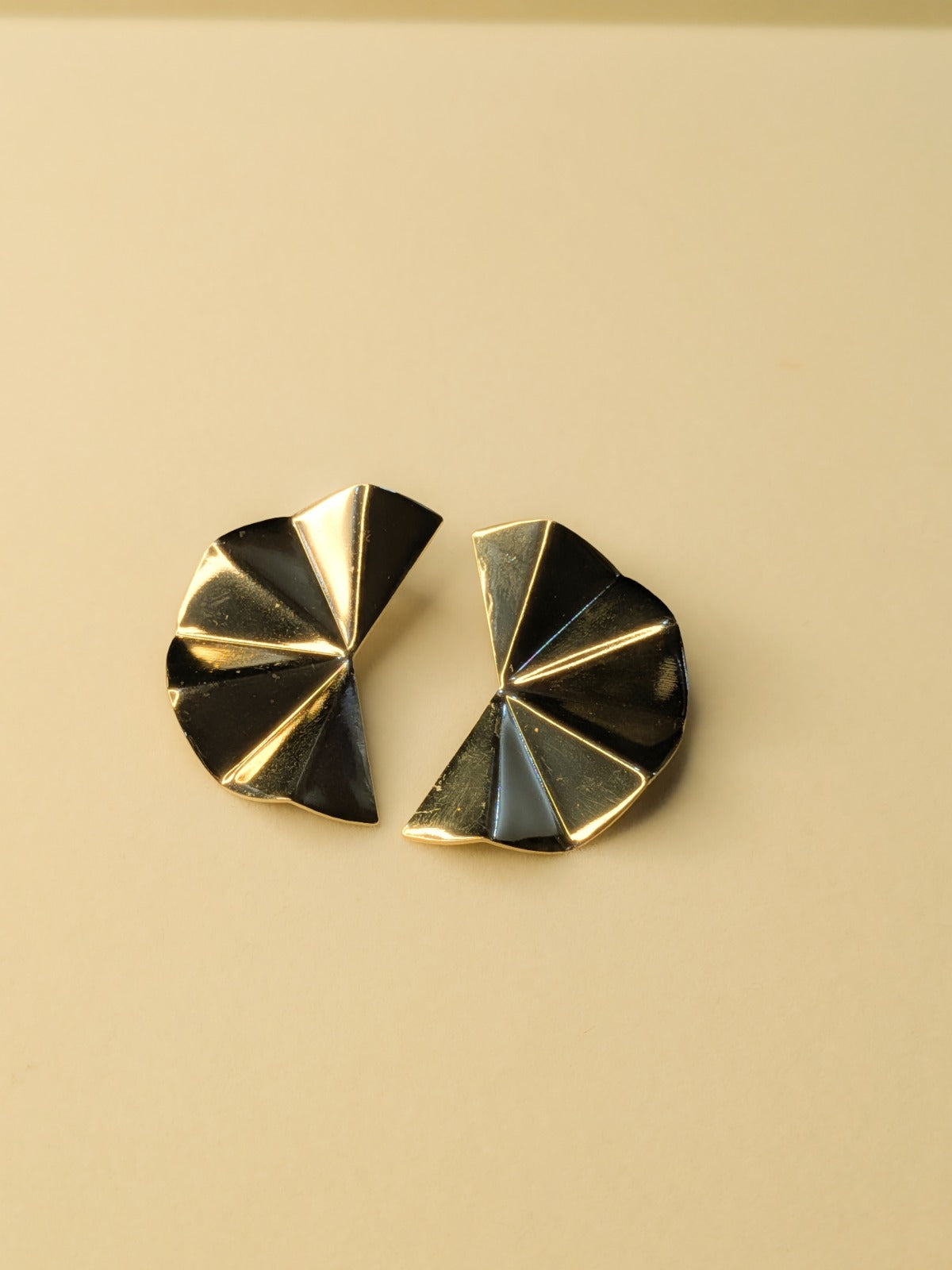Close up of Golden Eclipse Earrings featuring a modern geometric statement design