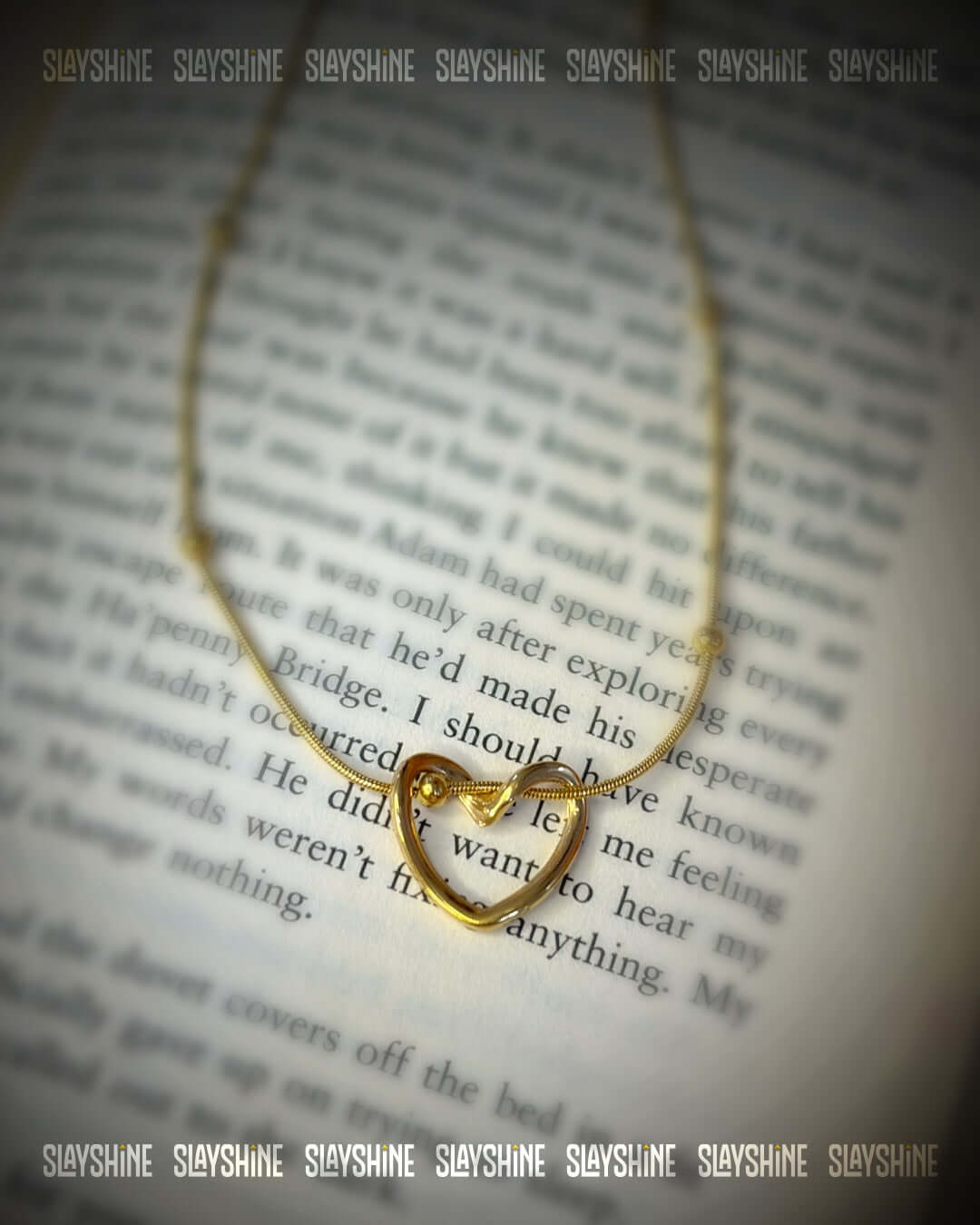 Elegant gold heart knot necklace displayed on an open book with anti tarnish finish